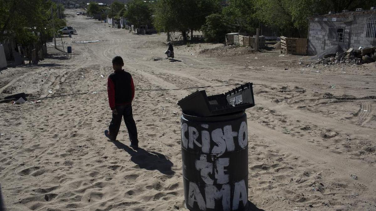 Un muchacho se aleja del basurero municipal donde tiró la carcasa de un televisor inutilizable, en el barrio Anapra de Ciudad Juárez, México, el jueves 30 de marzo de 2017, del otro lado de la frontera de Sunland Park, Nuevo México.