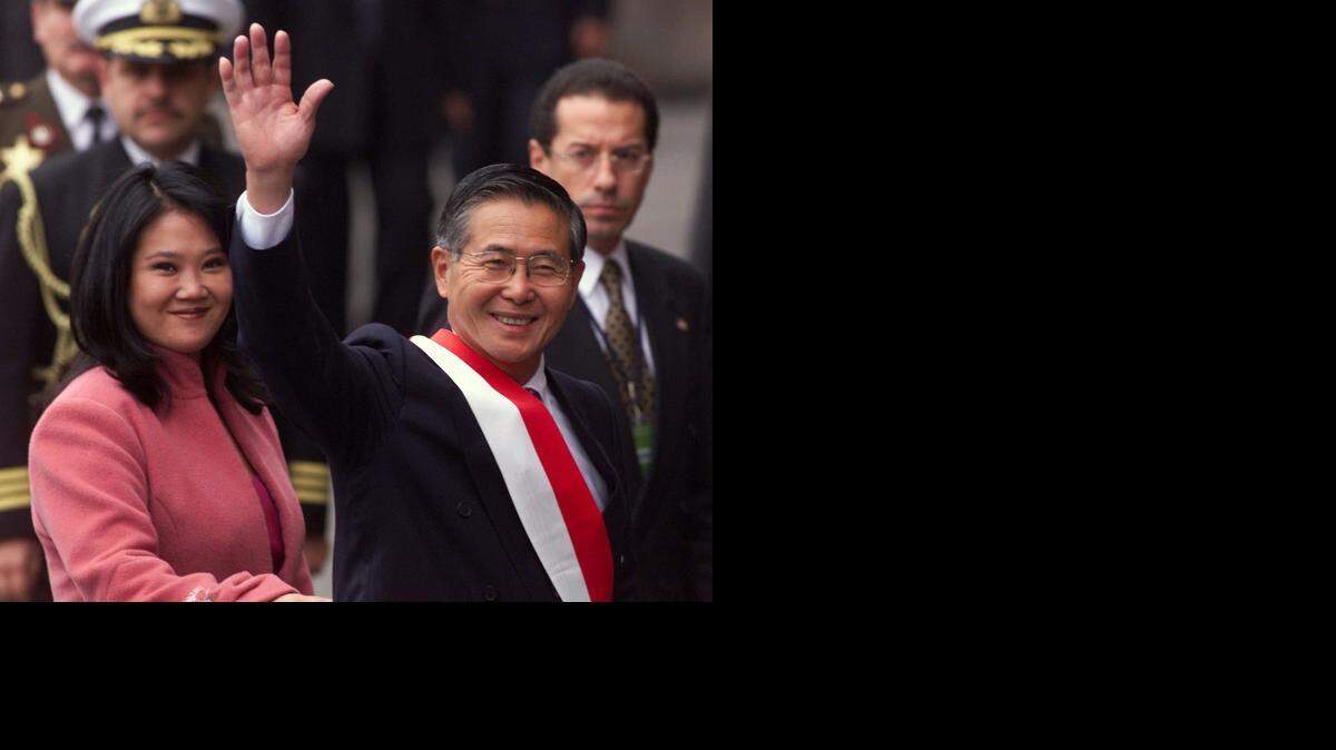 
El ex presidente de Perú, Alberto Fujimori, en compañía de su hija, Keiko, saluda al llegar a la catedral de Lima en el 2000, antes del acto de juramentación para un tercer mandato.

