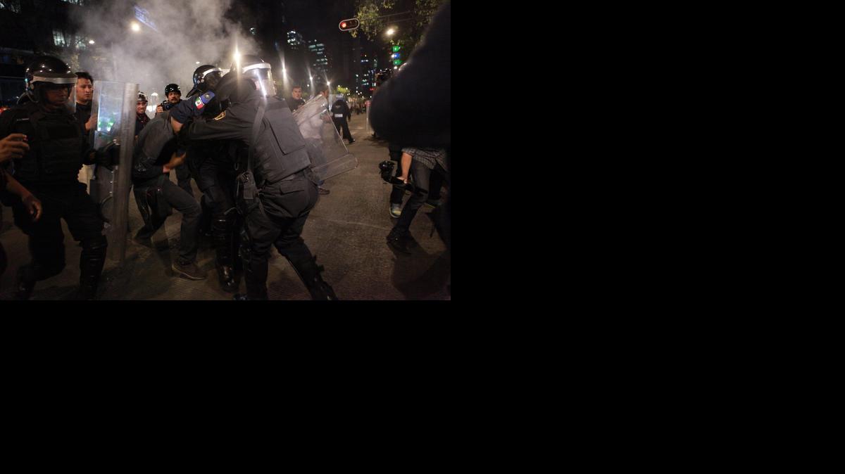 
 Un manifestante se enfrenta a la policía el lunes 1 de diciembre de 2014, después de una marcha por el paseo de la Reforma en Ciudad de México (México). EFE/José Méndez
