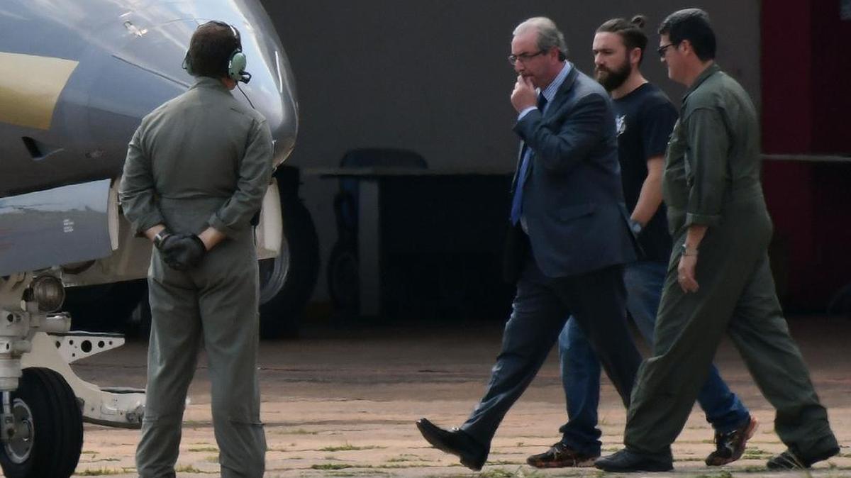 El ex presidente de la Cámara Baja de Brasil Eduardo Cunha (3d) camina, luego de ser detenido, hacia un avión de la Policía Federal, rumbo a la ciudad de Curitiba donde quedará preso el miércoles 19 de octubre de 2016, en Brasilia (Brasil), por orden del juez Sergio Moro.