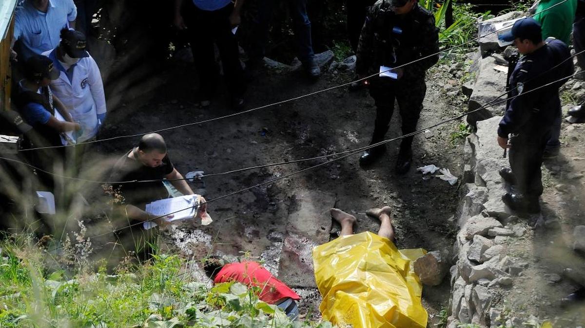 Investigadores reúnen evidencias el miércoles en la escena donde está el cadáver de un hombre que fue asesinado en Tegucigalpa, Honduras.