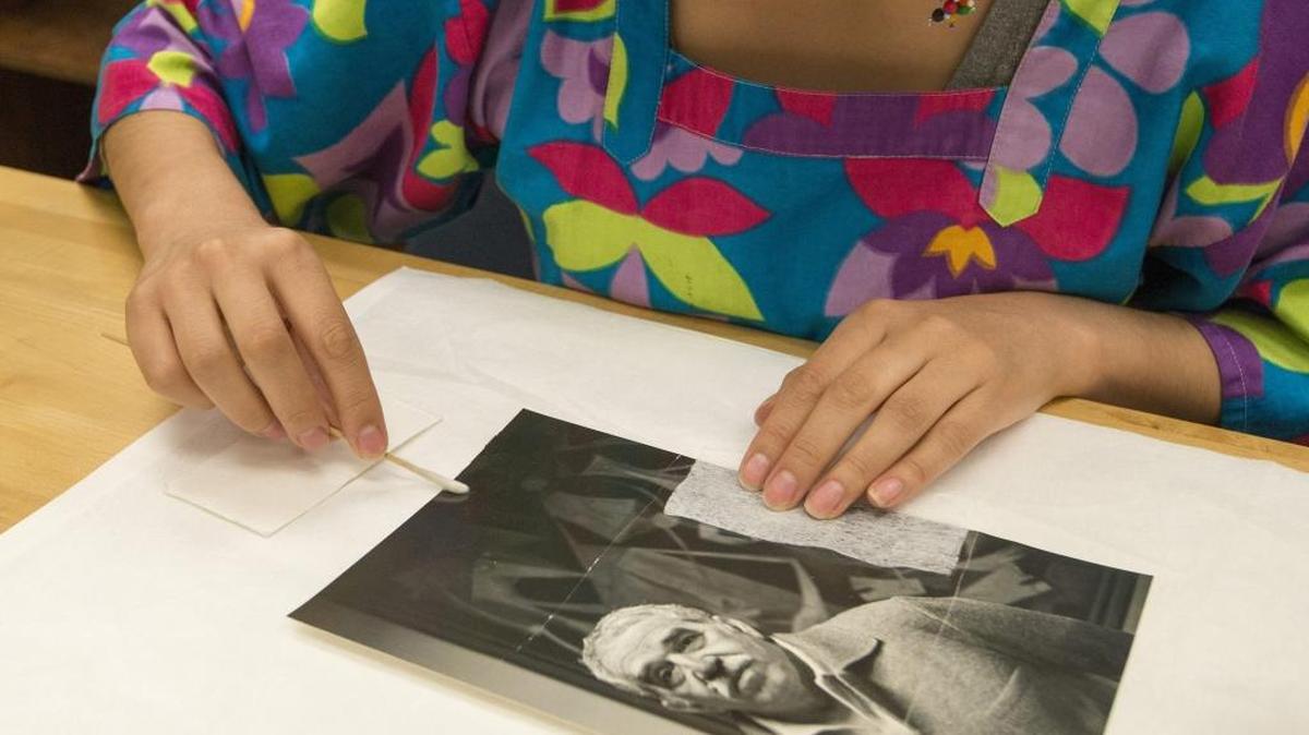 Fotografía sin fecha del trabajo de una restauradora llevando a cabo procesos de limpieza en la superficie de una foto a blanco y negro del escritor colombiano Gabriel García Márquez. La Universidad de Texas (UT) en Austin abrió el miércoles, a la investigación el archivo personal del nobel colombiano.
