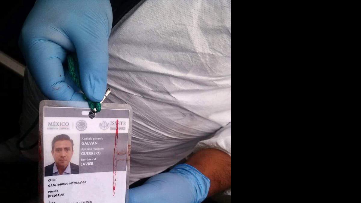 
Personal forense muestra el carné del asesinado presidente del PRI en Guadalajara, Javier Galván, acribillado dentro de su auto en esa ciudad del estado de Jalisco, en México. 
