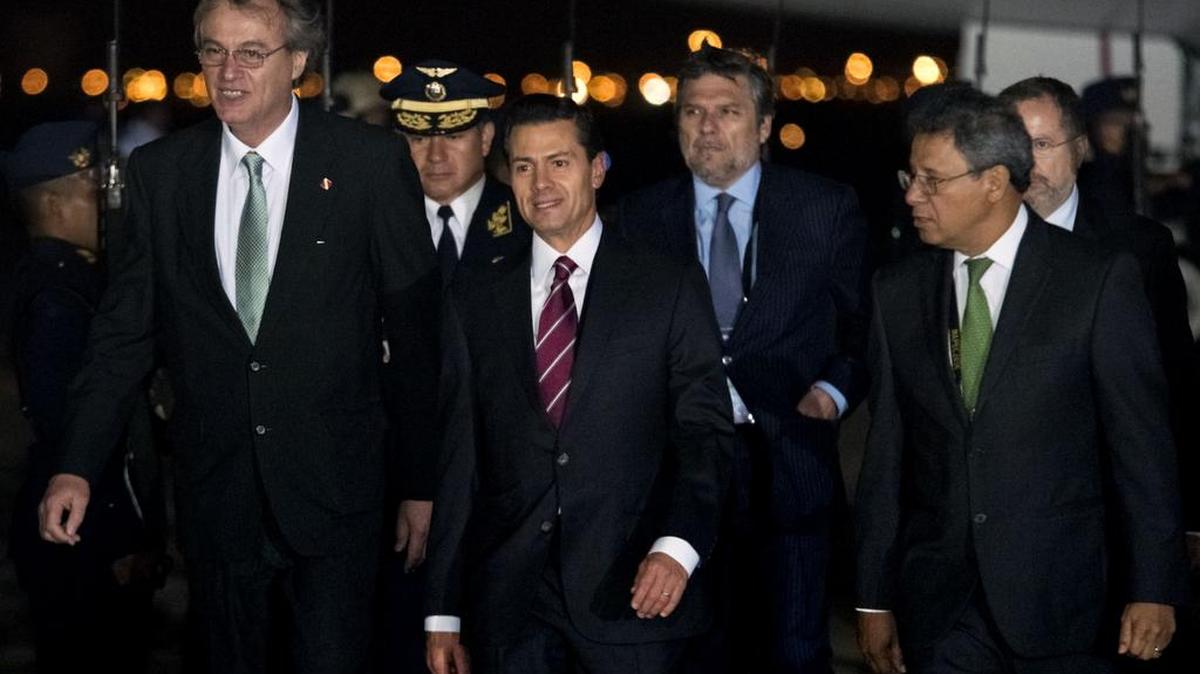 Esta foto tomada el 19 de noviembre de 2016 y publicada por la organización oficial APEC Perú 2016 muestra al presidente de México, Enrique Pena Nieto (C), caminando a su llegada al aeropuerto internacional Jorge Chávez en Lima para asistir a la Cumbre de Cooperación Económica Asia-Pacífico (APEC).