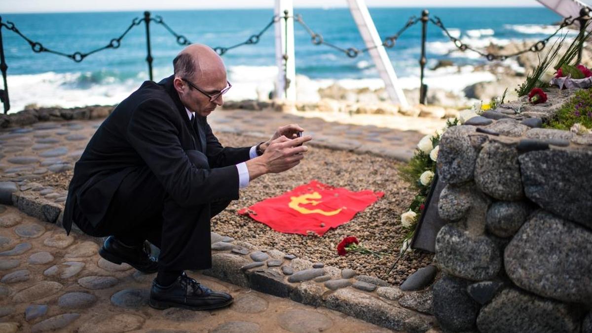 Un hombre toma una foto donde descansan los restos del poeta chileno Pablo Neruda en Isla Negra.