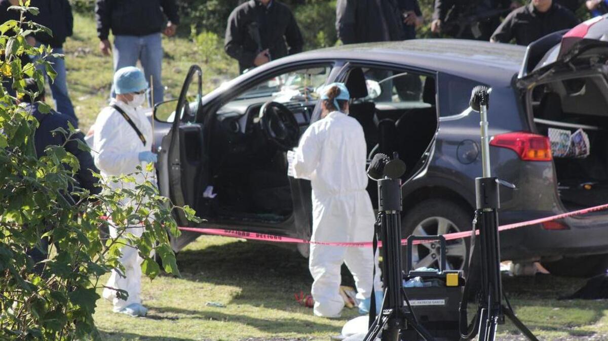 Peritos forenses y policía federal inspeccionan el martes 2 de agosto de 2016, el vehículo donde José Santamaría Zavala, alcalde de Huehuetlán el Grande, Puebla (México), fue asesinado a tiros cuando viajaba por una carretera rumbo a su domicilio, confirmaron fuentes oficiales.