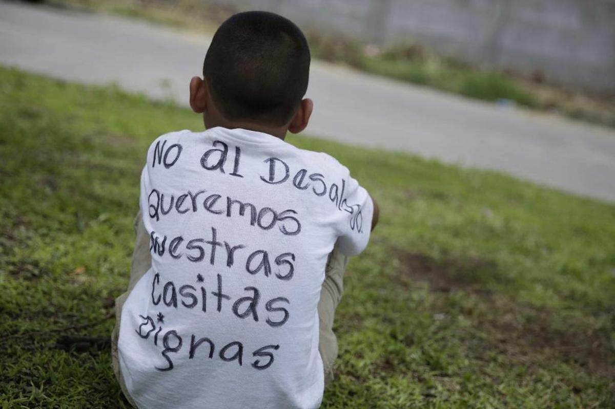 Un niño usa una camiseta con un mensaje de protesta en la comunidad El Espino después de que se anunciara que una orden judicial de desalojo en contra de los habitantes del sector será ejecutada por un juez local.