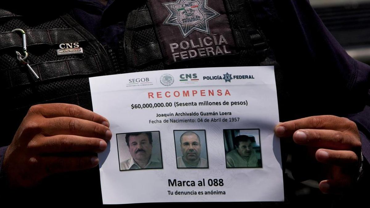 Un policía mexicano muestra en julio un cartel con la foto de Joaquín “El Chapo” Guzmán y una recompensa a quien de información sobre su paradero. 