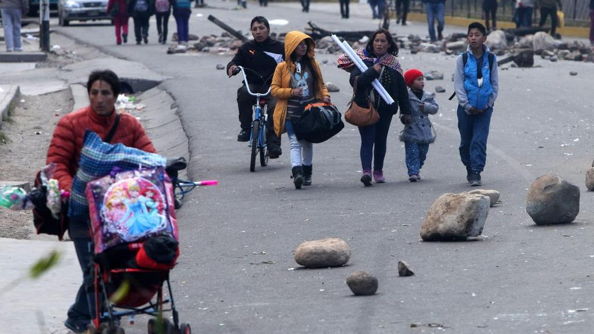 
Un grupo de personas camina entre barricadas instaladas por manifestantes el martes, en la Oroya, Perú. Una persona murió y otras 63 resultaron heridas durante los enfrentamientos que se presentaron entre manifestantes en huelga y policías en el centro de Perú. 
