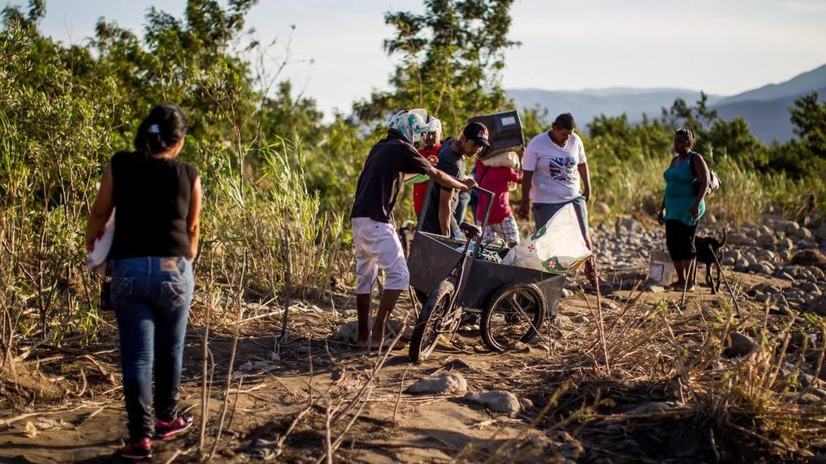 
 Un grupo de personas camina por una trocha del sector "La Parada" luego de cruzar el río Tachira, que divide a Venezuela y Colombia, hoy, sábado 29 de agosto de 2015, en el sector "La Invasión", cerca a Cúcuta (Colombia). 
