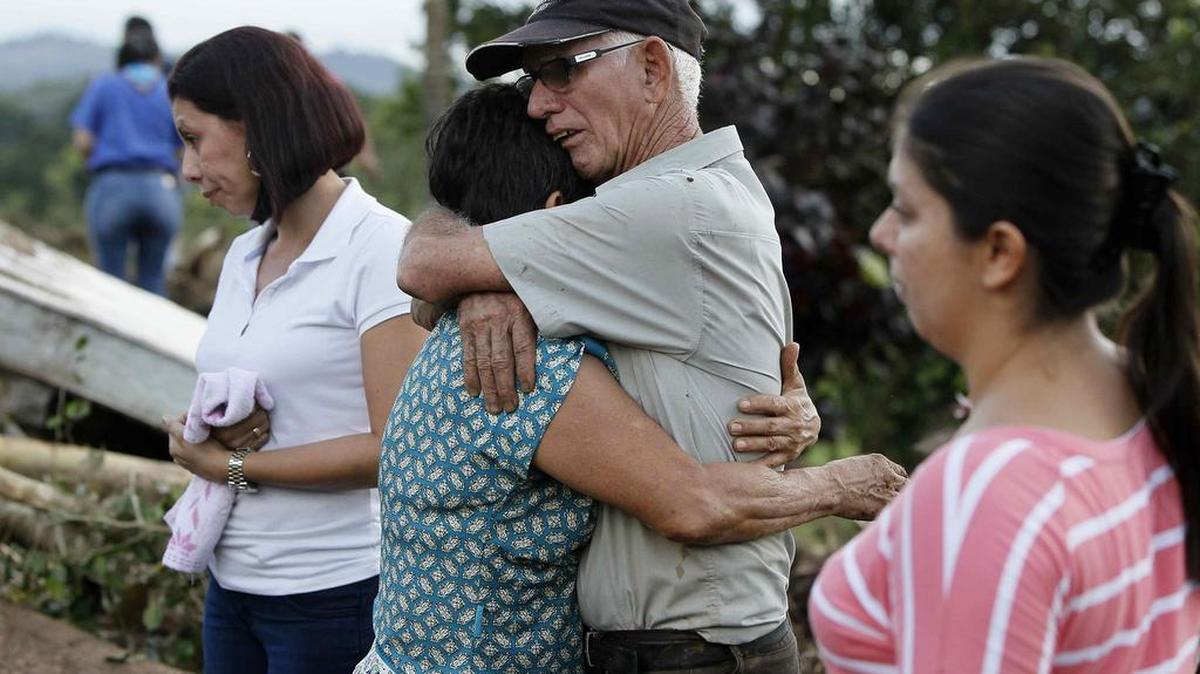 Familiares de una menor desaparecida lloran el viernes 25 de noviembre de 2016, mientras vecinos participan en las labores de recuperación de cuerpos tras el paso del huracán Otto que afectó principalmente el norte del país, en Bijagua (Costa Rica).