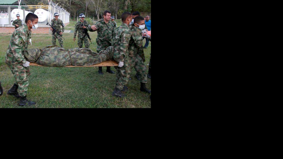 Foto de archivo que muestra a un grupo de militares colombianos trasladando el cadáver de un guerrillero. 
