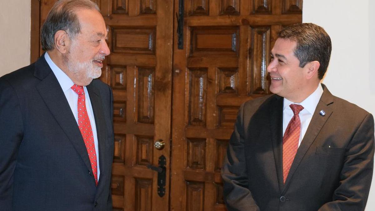 El presidente de Honduras, Juan Orlando Hernández (der.), habla el viernes con el magnate mexicano Carlos Slim, tras la firma de un convenio de colaboració.