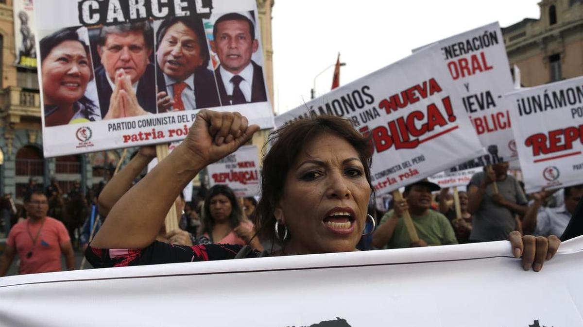 Una mujer participa en una marcha anticorrupción con un cartel con imágenes de tres ex presidentes peruanos, Alan García, Alejandro Toledo y Ollanta Humala, en Lima, Perú, jueves, 16 de febrero de 2017.