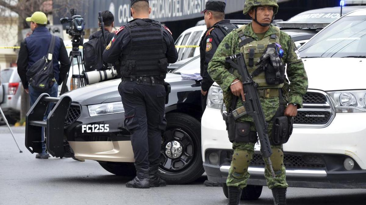 Un soldado y policía resguardan el exterior de una escuela privada en Monterrey, México, el miércoles, 18 de enero 2016.