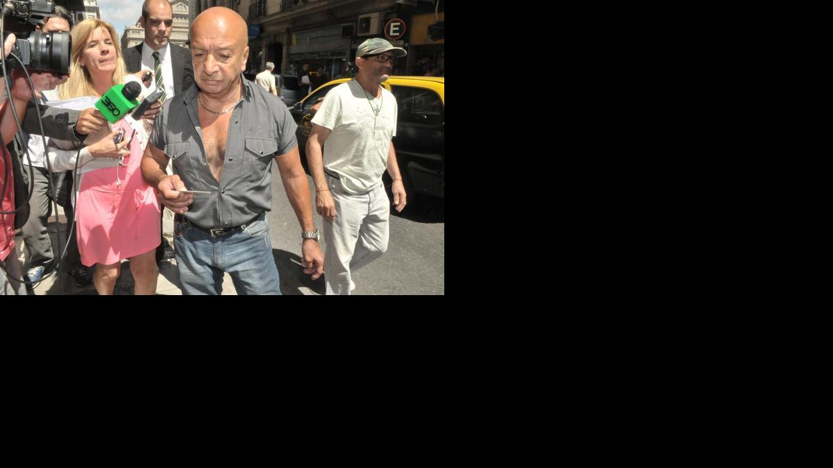 
Walter (centro), el cerrajero que abrió la puerta del apartamento del fiscal argentino Alberto Nisman, sale de la Fiscalía después de declarar el miércoles 21 de enero de 2015, en Buenos Aires. El cerrajero dijo que la puerta de servicio no estaba cerrada con llave, aunque tenía las llaves puestas en la cerradura, y podría haberla abierto “cualquiera”.
