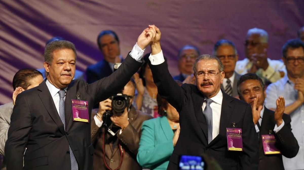 
El presidente de República Dominicana, Danilo Medina (der.), alza la mano el domingo junto al ex mandatario Leonel Fernández, momentos después de que Medina tomara juramento como candidato presidencial por el Partido de la Liberación Dominicana. 
