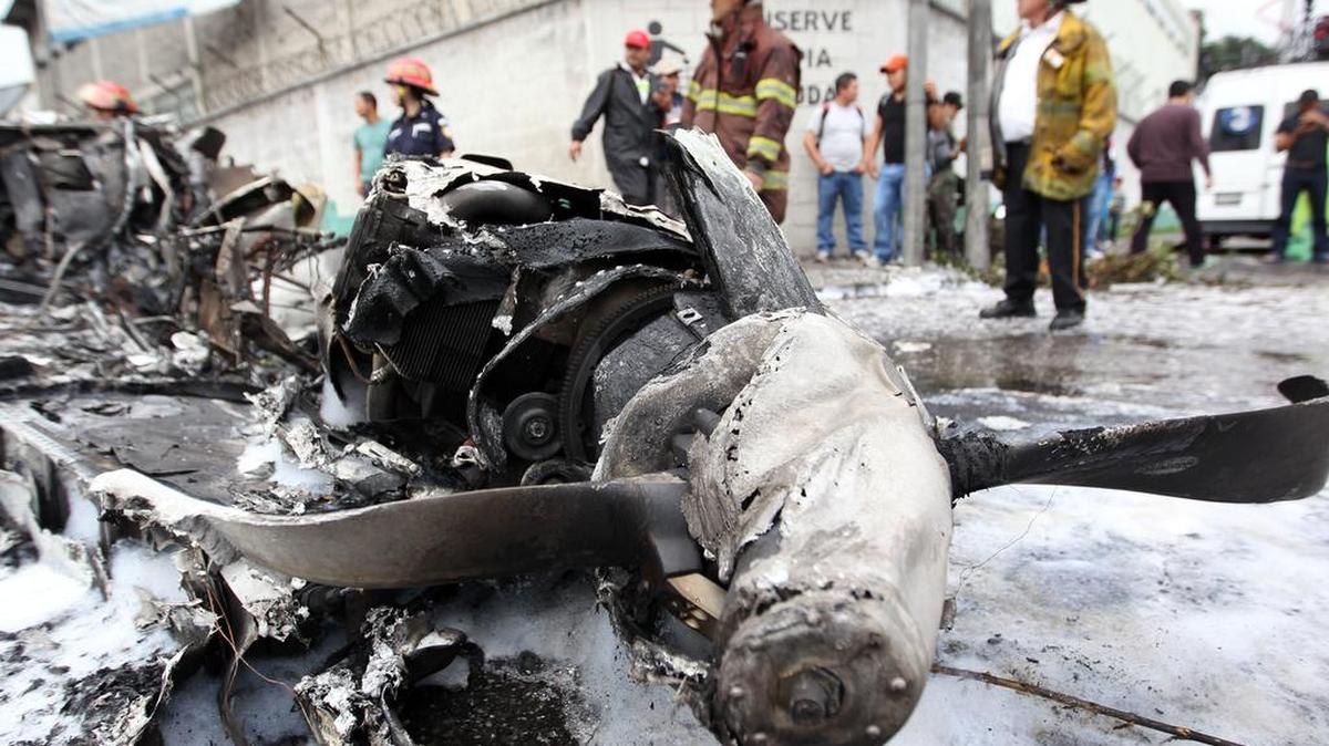 Bomberos revisan los restos de una avioneta accidentada este sábado 21 de noviembre de 2015, en una calle de Ciudad de Guatemala (Guatemala).