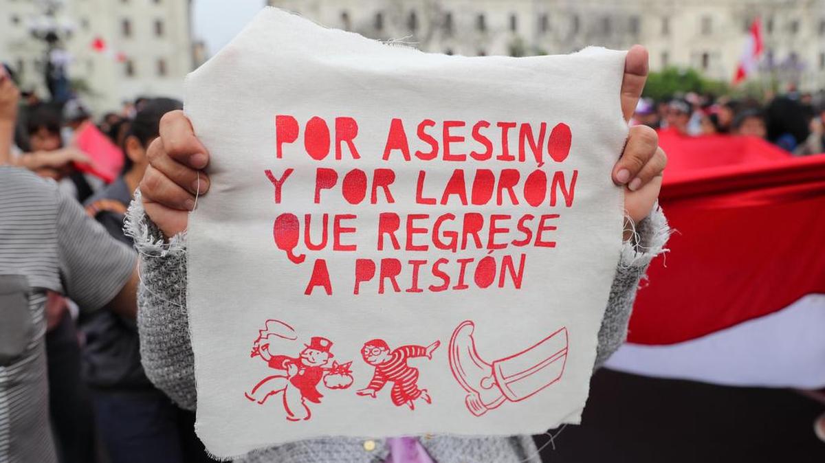 Una mujer muestra un pañuelo en el que se lee "por asesino y por ladrón que regrese a prisión" durante una marcha el jueves 28 de diciembre de 2017, por las principales calles del centro histórico de Lima (Perú).