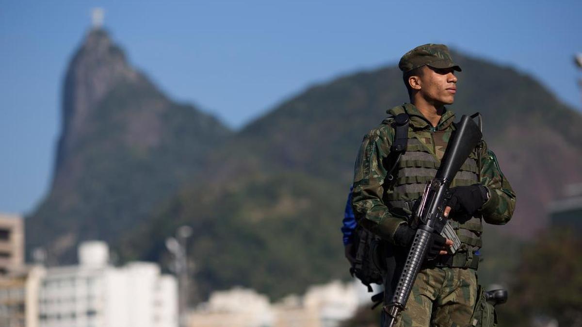 Con el Cristo Redentor detrás, un soldado patrulla la playa de Botafogo en Rio. Las medidas de seguridad en Brasil por la cercanía de las Olímpiadas se han reforzado.