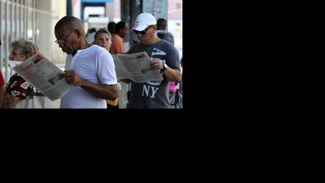 
Dos hombres leen el diario oficial Granma en La Habana.  