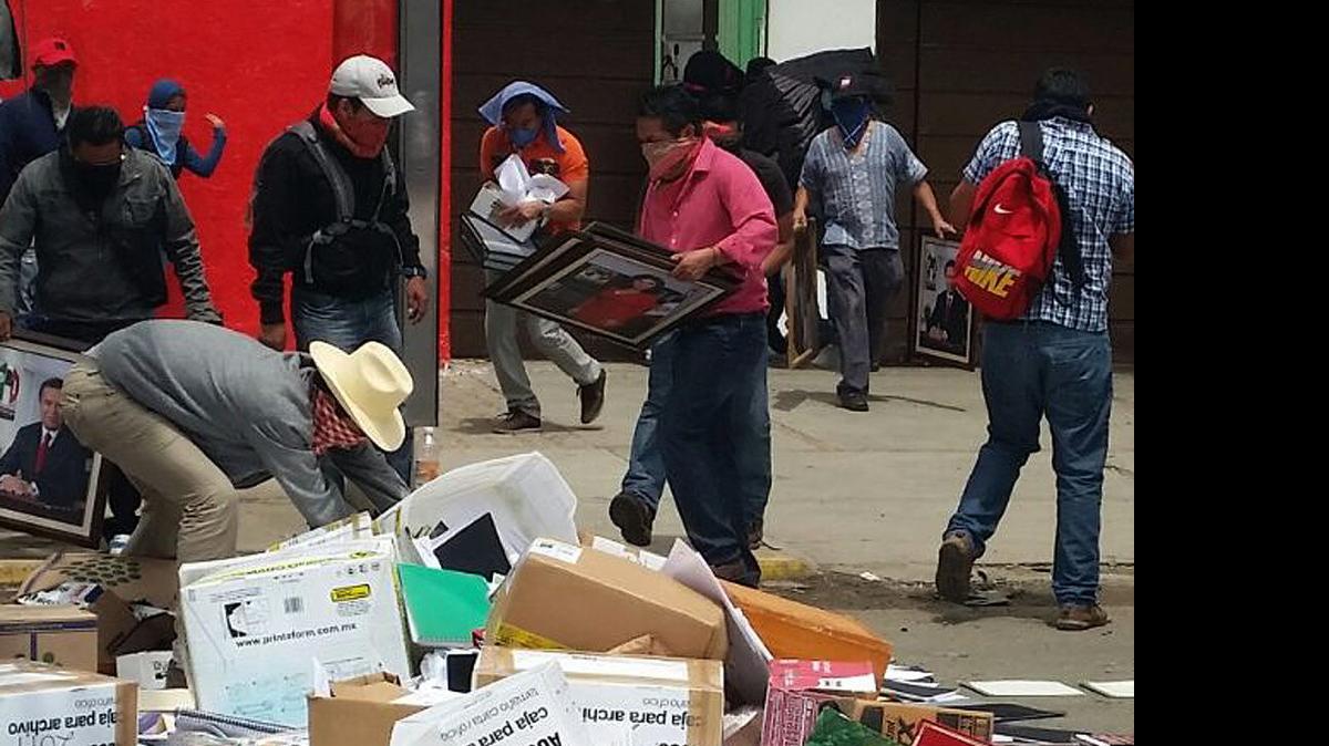
Maestros de la Coordinadora Nacional de Trabajadores de la Educación (CNTE) mientras irrumpen en una sede del Partido Revolucionario Institucional (PRI) en Oaxaca, México, donde quemaron papelería, documentación y mobiliario.
