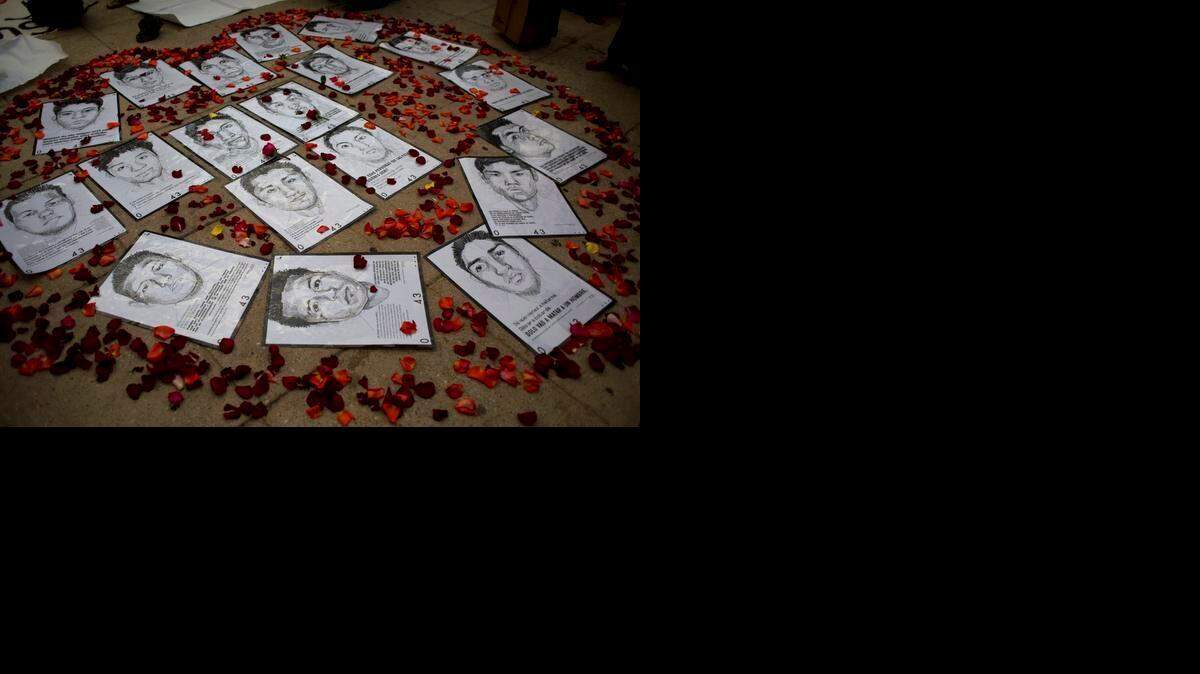 
Bocetos de algunos de los 43 estudiantes mexicanos rodeados por petalos de rosas formando un corazón, durante una protesta la semana pasada en Ciudad de México.
