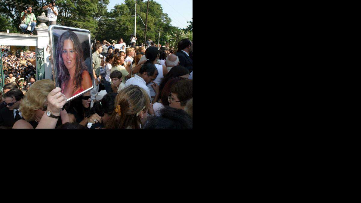 
Una de las muchas imágenes de Cecilia Cubas, hija del ex presidente paraguayo Raúl Cubas, es mostrada durante su sepelio. Los restos de la joven fueron hallados en una casa de las afueras de la capital paraguaya tras casi cinco meses de su secuestro. Foto archivo.
