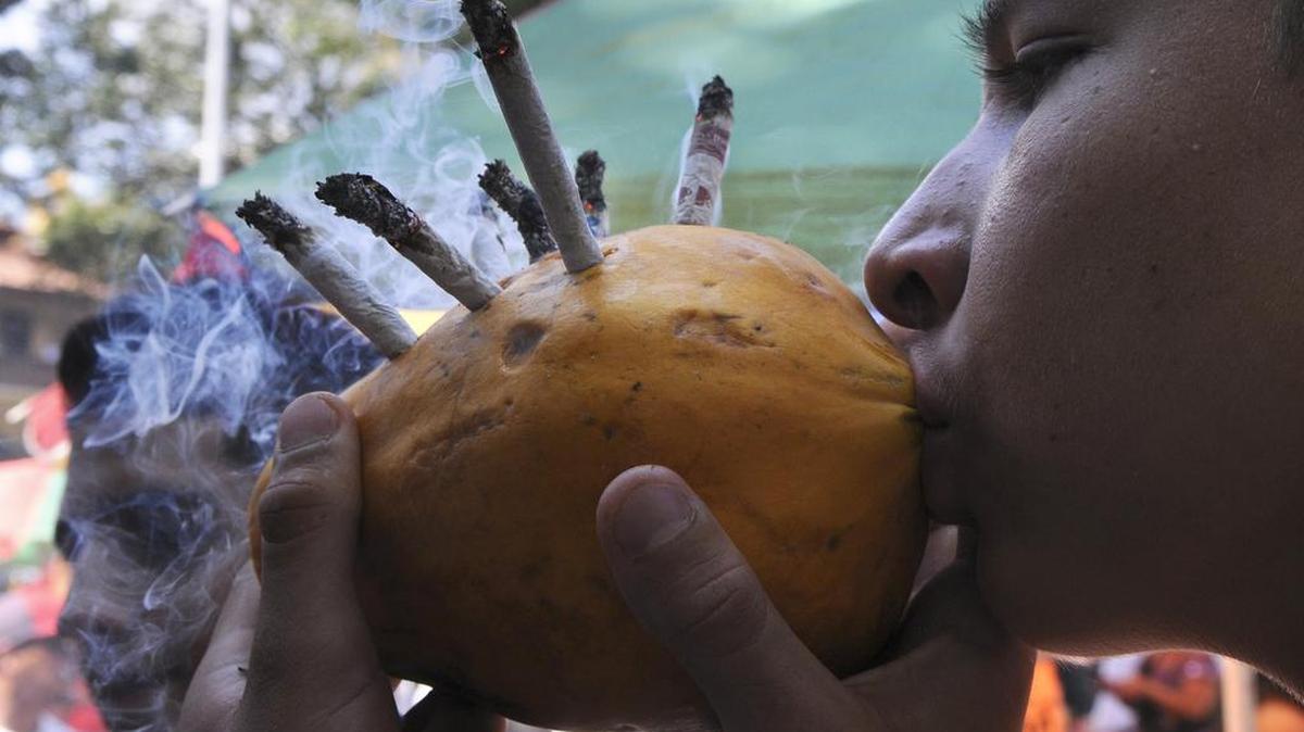 Un joven fuma marihuna durante una manifestación en Medellín, en mayo del 2013. Colombia prepara un decreto para legalizar el cultivo y la comercialización de la marihuana con fines medicinales, anuncio que fue hecho este jueves por el ministro de Justicia Yesid Reyes.