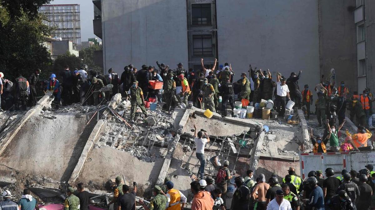 Socorristas, bomberos, policías, soldados y voluntarios retiran escombros de un edificio en busca de sobrevivientes tras un poderoso terremoto en la Ciudad de México el 19 de septiembre de 2017.