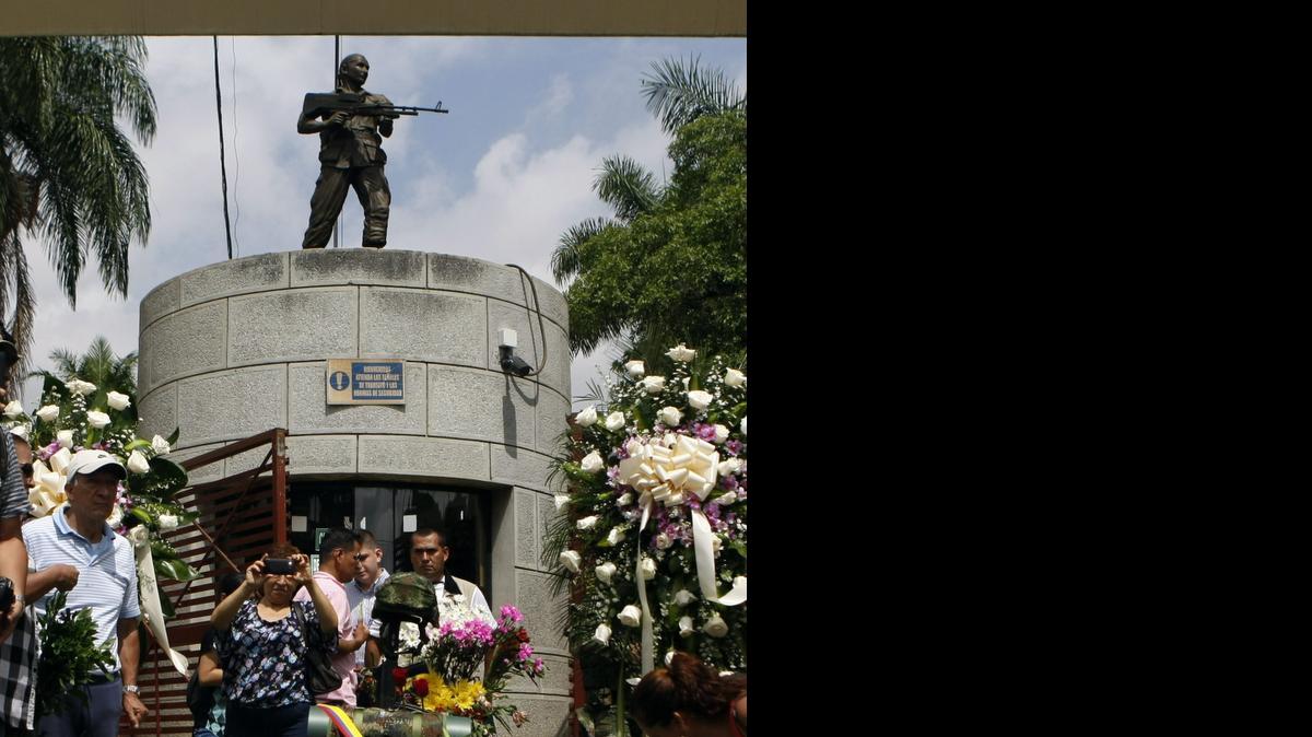 
Un grupo de personas rinde homenaje el jueves a los 11 soldados del ejército colombiano que murieron después de un ataque de las FARC, en un altar improvisado frente a un cantón militar de la ciudad de Cali.


