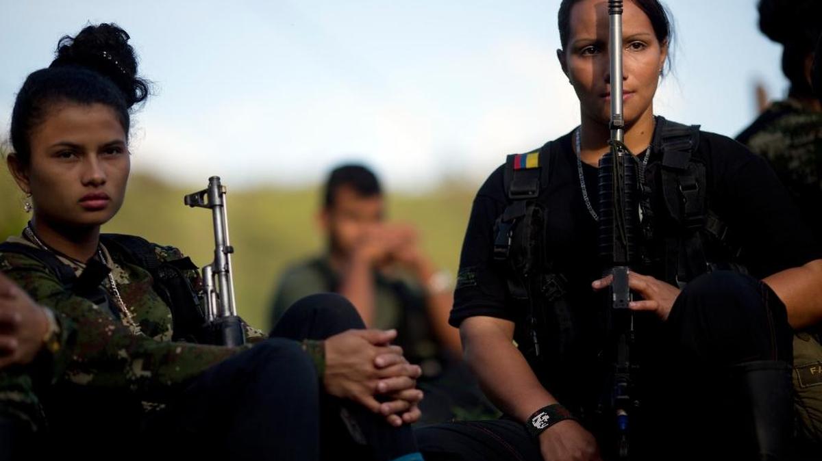 Juliana, de 20 años, y Mariana, de 24, guerrilleras de las FARC, escuchan a un comandante hablar sobre el avance en las conversaciones de paz, en enero.