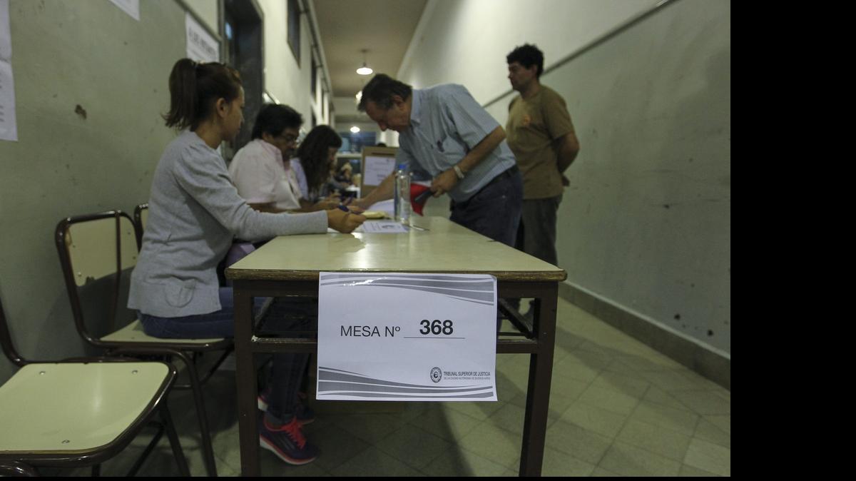 
Un ciudadano deposita su voto el domingo en un centro electoral de Buenos Aires. Los colegios electorales de esa ciudad argentina abrieron sus puertas a primera hora para que 2.5 millones de habitantes puedan elegir a los candidatos que compiten por suceder al líder opositor Mauricio Macri en la alcaldía porteña.

