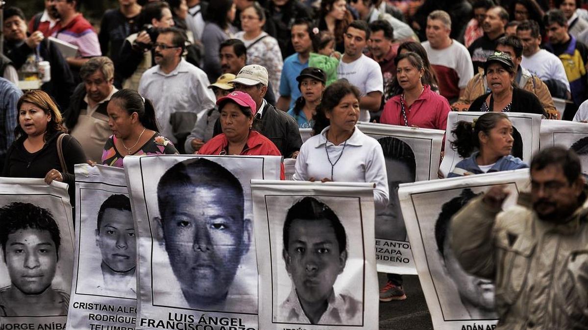 
Manifestantes en la Ciudad de México muestran fotos de algunos de los 43 estudiantes desaparecidos.
