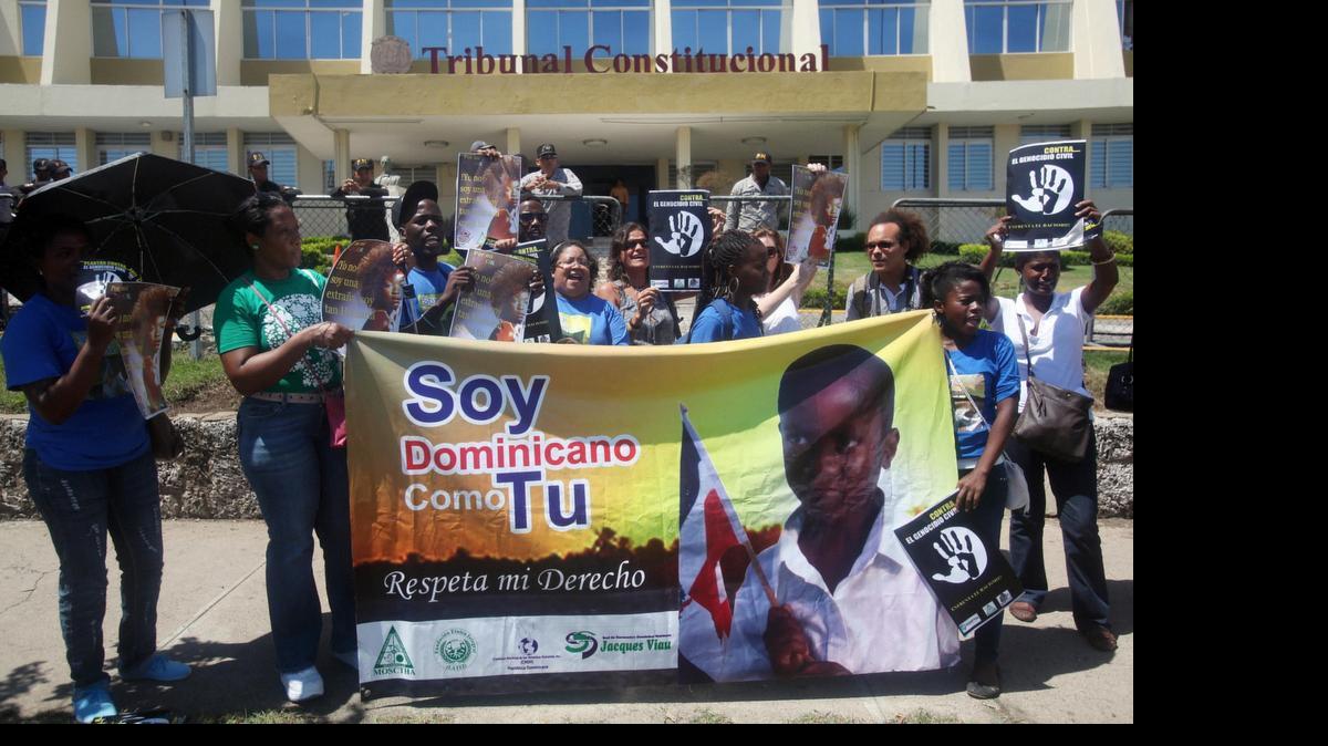
Unos manifestantes protestan frente a la sede del Tribunal Constitucional (TC) de República Dominicana, en Santo Domingo. por un fallo que establece que a las personas nacidas en el país de padres extranjeros en tránsito después de 1929 no les corresponde la nacionalidad dominicana. 
