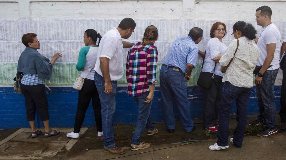 Un grupo de personas busca su nombre en los listados para saber su lugar exacto de votación el domingo 5 de noviembre de 2017, en un puesto electoral de Managua (Nicaragua).