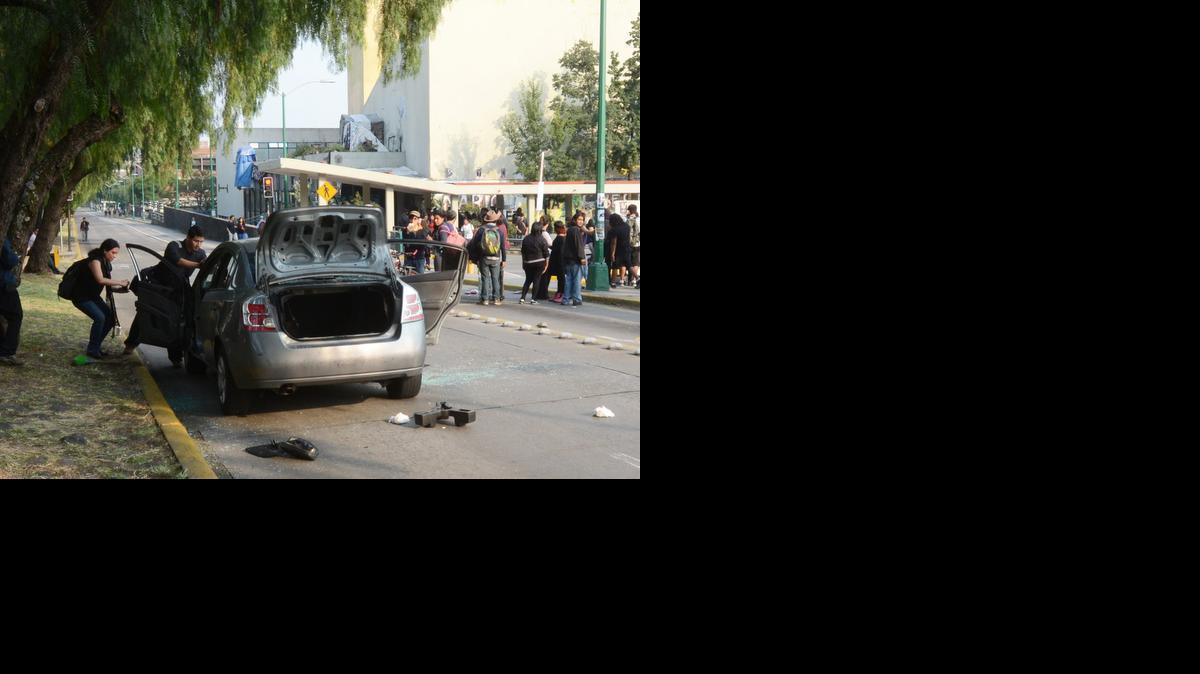 
Estudiantes desmantelan el sábado el auto que conducía un grupo de peritos de la policía que fueron agredidos por jóvenes encapuchados en las inmediaciones de la Universidad Nacional Autónoma de México. 
