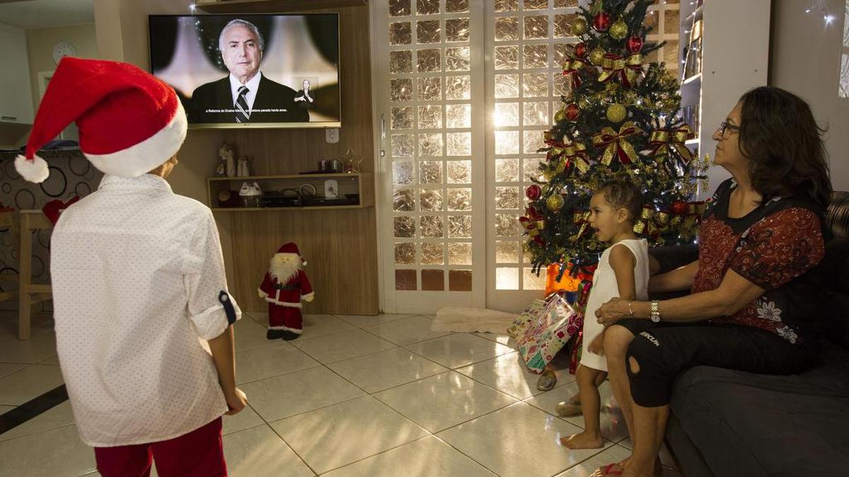 Una familia brasileña observa al presidente brasileño Michel Temer durante una alocución el sábado 24 de diciembre 2016, en Brasilia (Brasil).