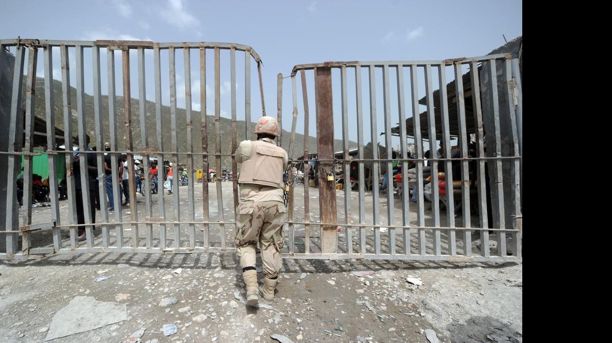 
Un soldado dominicano cierra la puerta que está en la frontera con Haití, entre Malpasse y Jimani, el sábado. El gobierno dominicano concluyó el 17 de junio la inscripción de los extranjeros que viven en el país desde antes de octubre del 2011 sin permiso migratorio
