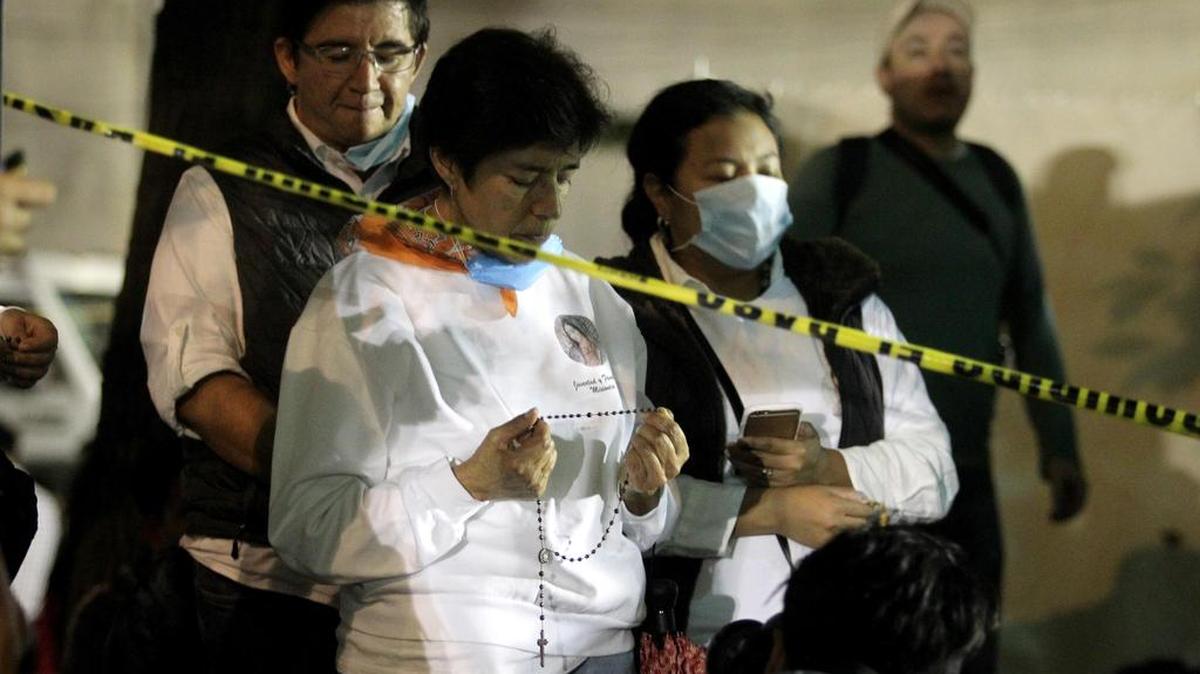 Familiares de personas que aún se encuentran desaparecidas en los edificios colapsados rezan durante las labores de rescate el domingo 24 de septiembre de 2017, en Ciudad de México (México).