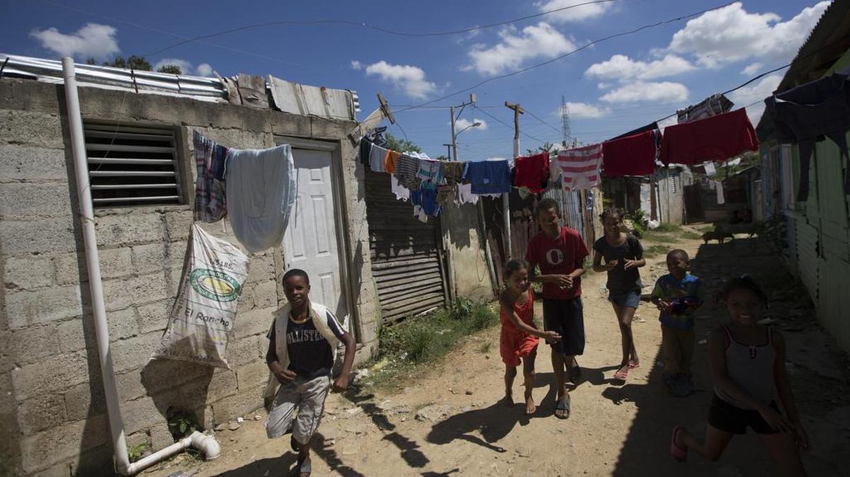 Fotografía fechada el 11 de octubre de 2017 que muestra a varios niños mientras juegan en las calles del albergue de Canta La Rana, en el municipio dominicano de Los Alcarrizos, en Santo Domingo (República Dominicana).