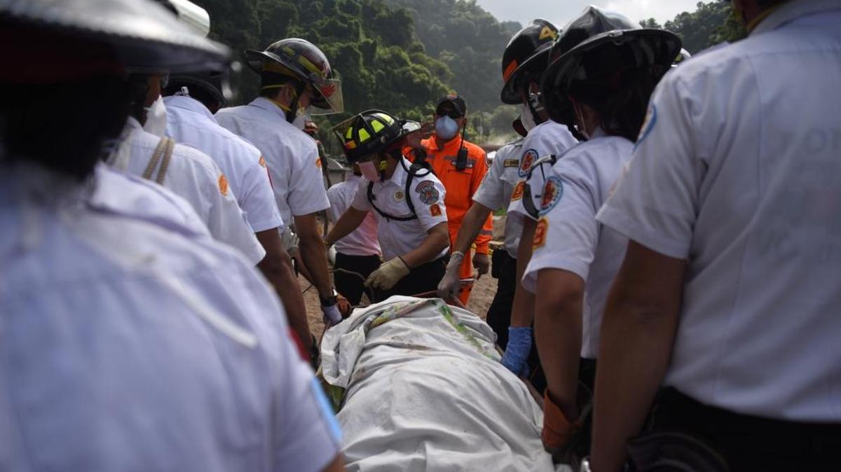
Bomberos trasladan un cuerpo recuperado en El Cambray II, en Santa Catarina Pinula, Guatemala, donde un deslizamiento de tierra sepultó varias casas. 
