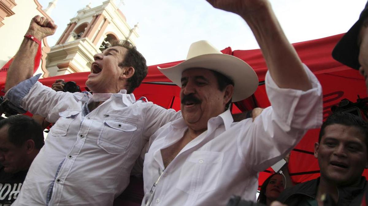 El líder opositor Salvador Nasralla, a la izquierda, aplaude junto con el ex presidente Manuel Zelaya, en una concentración donde reafirmó su reivindicación de la presidencia de Honduras, en el parque central de San Pedro Sula, Honduras, el sábado 6 de enero de 2018.