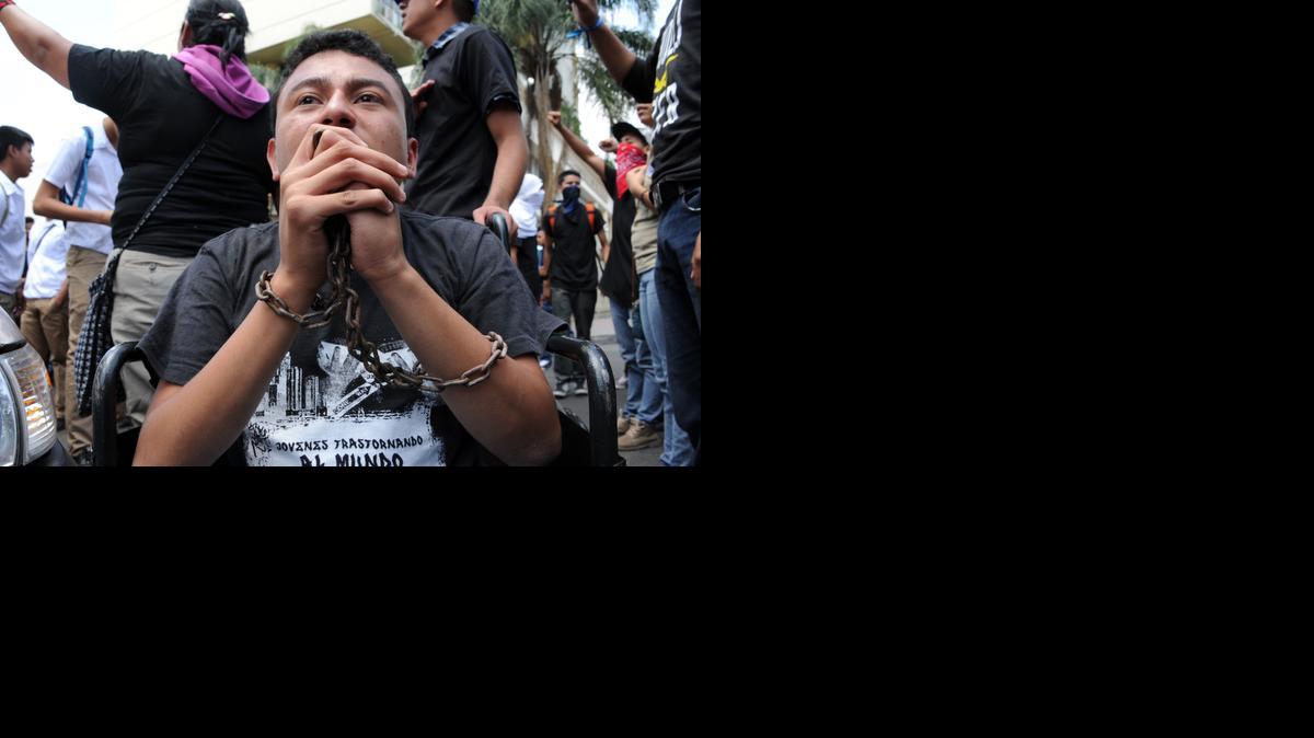 
Un joven con las manos encadenadas participa en la protesta por la muerte de cuatro estudiantes asesinados, en Tegucigalpa.

