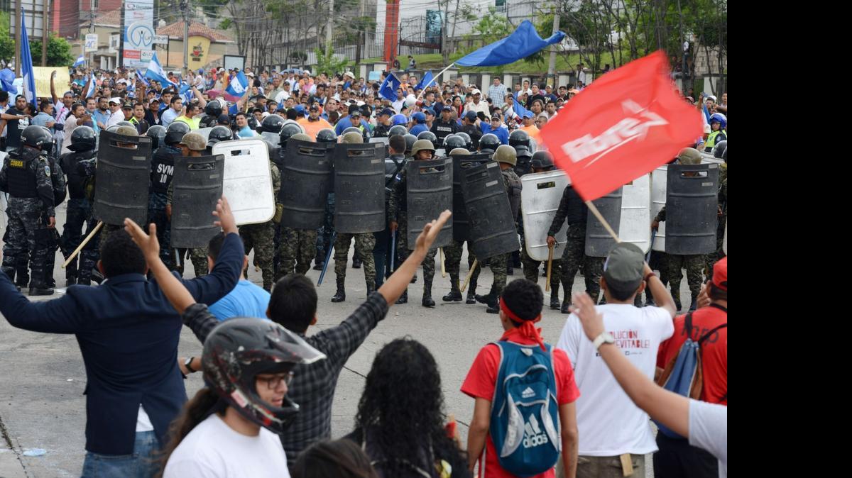
Fuerzas de seguridad de Honduras se interponen el domingo entre los seguidores del ex presidente hondureño Manuel Zelaya y quienes respaldan al actual gobernante Juan Orlando Hernández, durante una manifestación para conmemorar los seis años del golpe de Estado contra Zelaya. 


