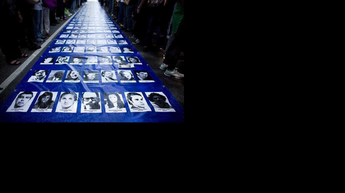 
Fotos de desaparecidos durante la dictadura argentina, expuestas en Buenos Aires, donde un ex militar ha roto el código de silencio y ha dicho donde enterraban a sus víctimas.
