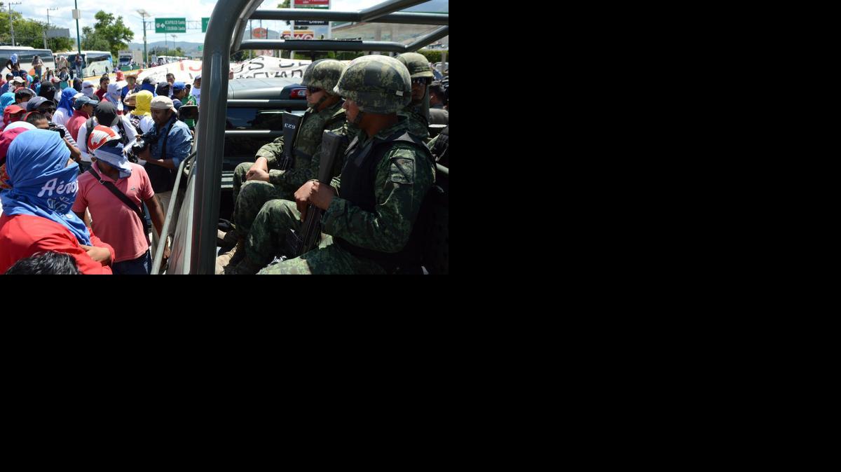 
Familiares y maestros de 43 jóvenes desaparecidos increpan a militares a su paso el domingo por el trámo carretero Parador del Marquéz-Chilpancingo donde tomaron la caseta de cobro. 
