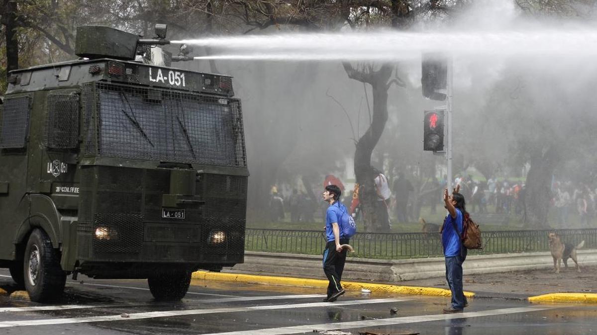 
Un grupo de manifestantes se enfrenta a la policía antidisturbios durante una marcha por la resistencia mapuche, en Santiago de Chile.

