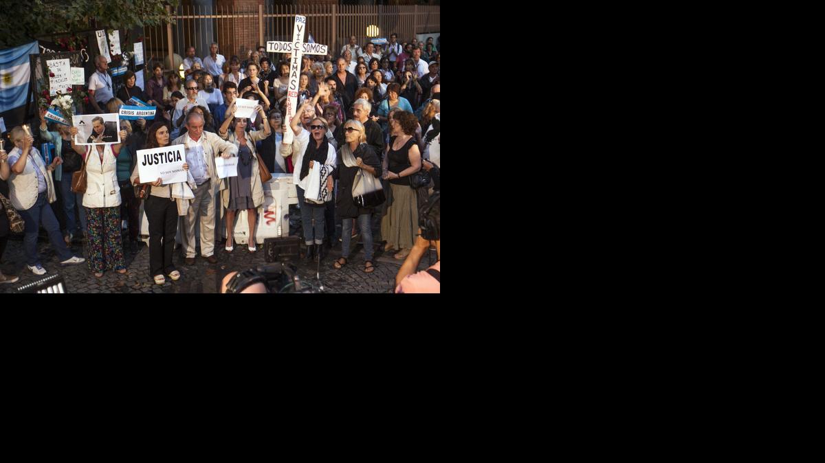 
Manifestantes sostienen rosas y carteles para pedir justicia en las inmediaciones donde se realiza el velatorio del fiscal Alberto Nisman, el miércoles en Buenos Aires. Nisman falleció de un tiro en la cabeza en circunstancias aún por aclarar el pasado 18 de enero.
