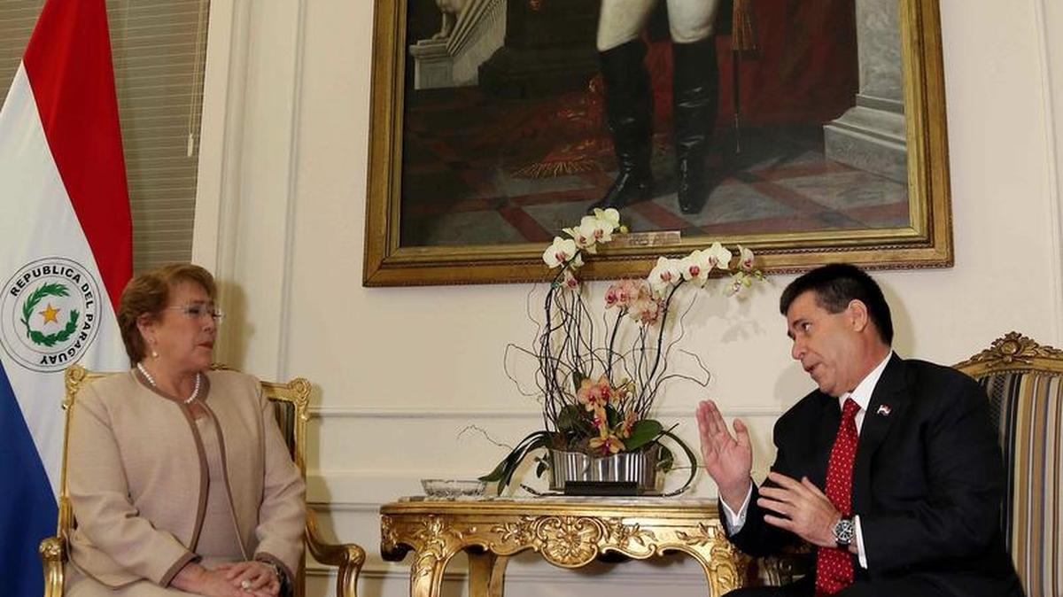
El presidente de Paraguay, Horacio Cartes (der.), se reúne con su par de Chile, Michelle Bachelet, este viernes a su llegada a la sede del Palacio de López en Asunción.



